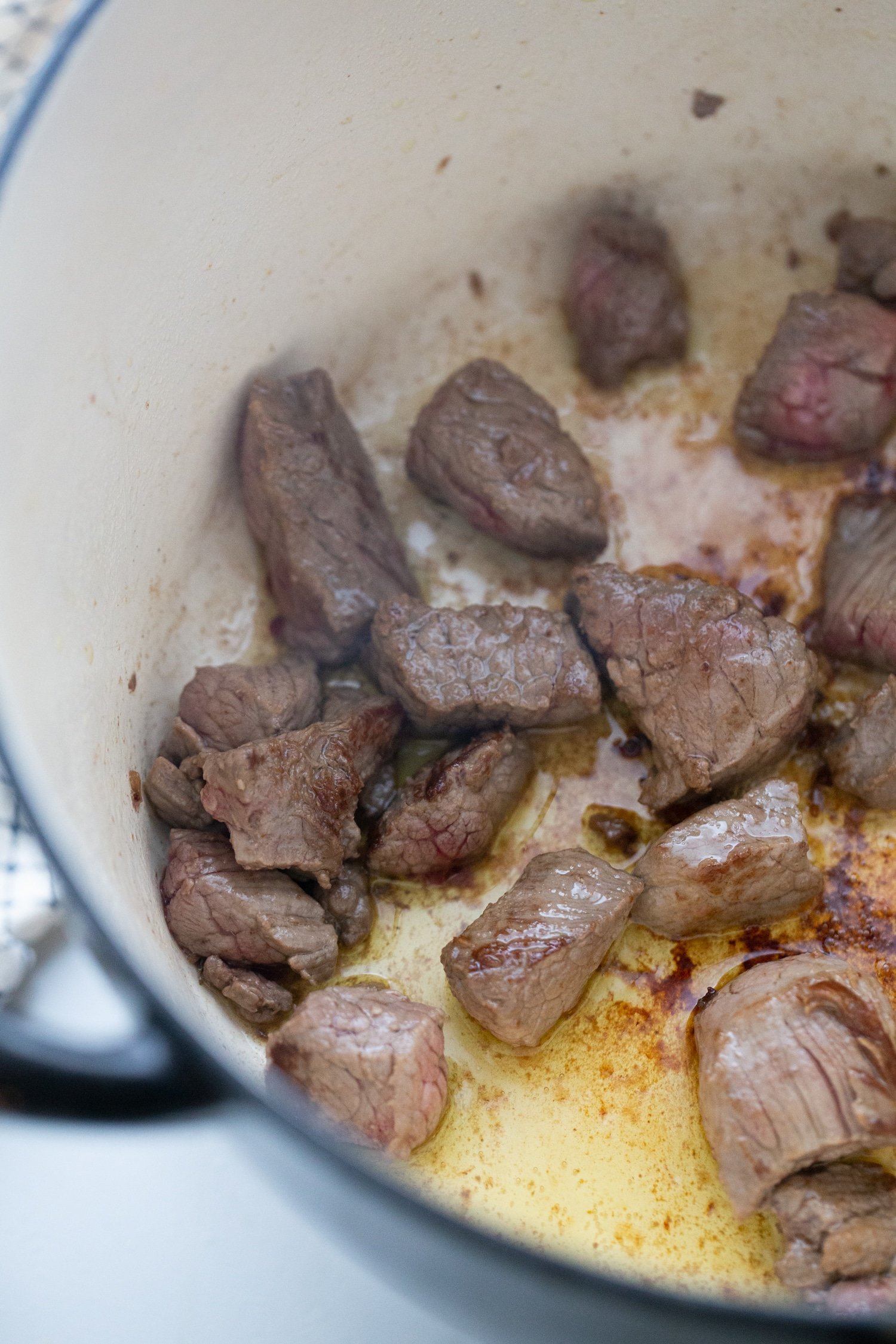 beef stew meat searing in a dutch oven