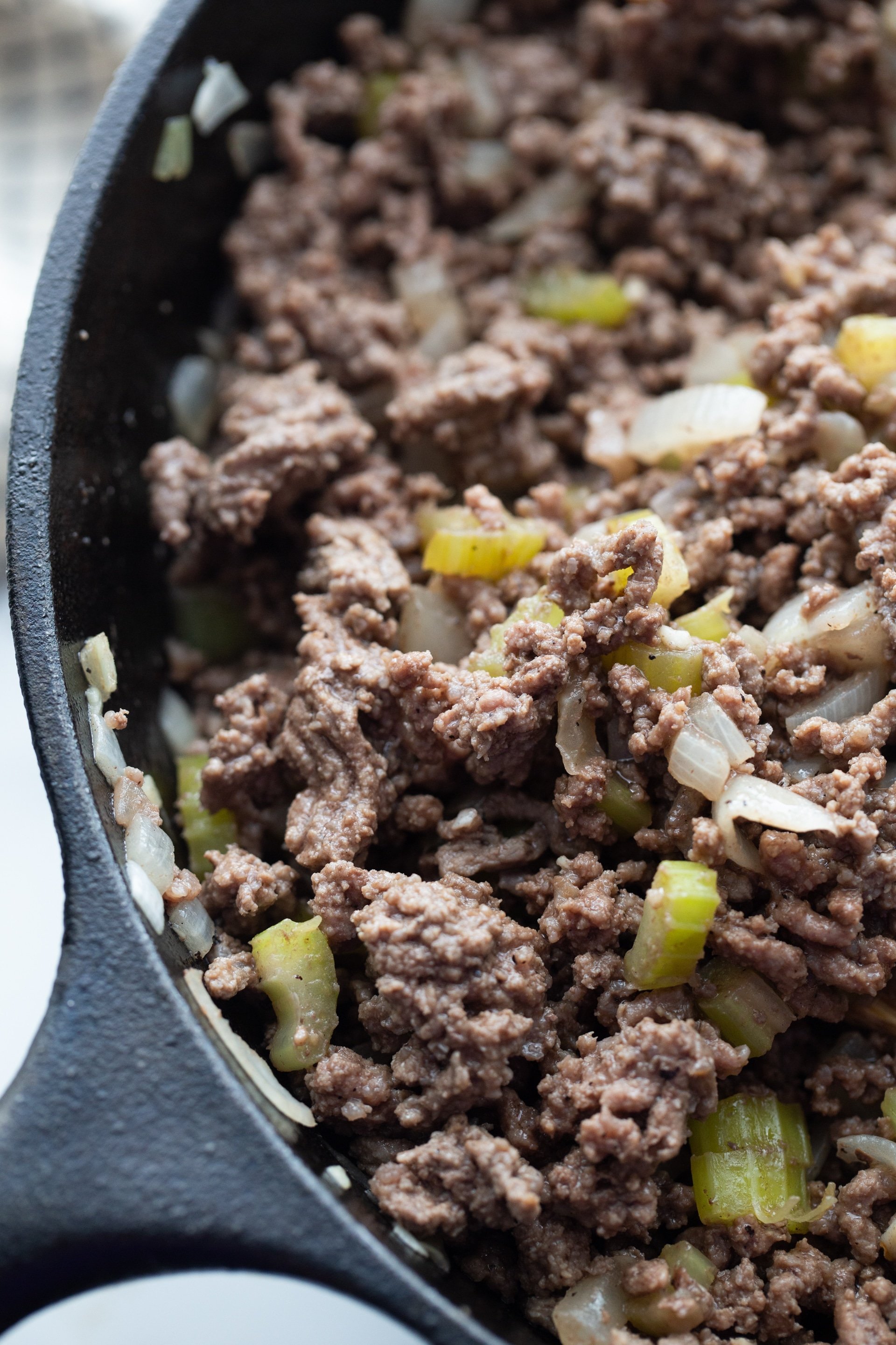 ground beef with onions and peppers in a skillet