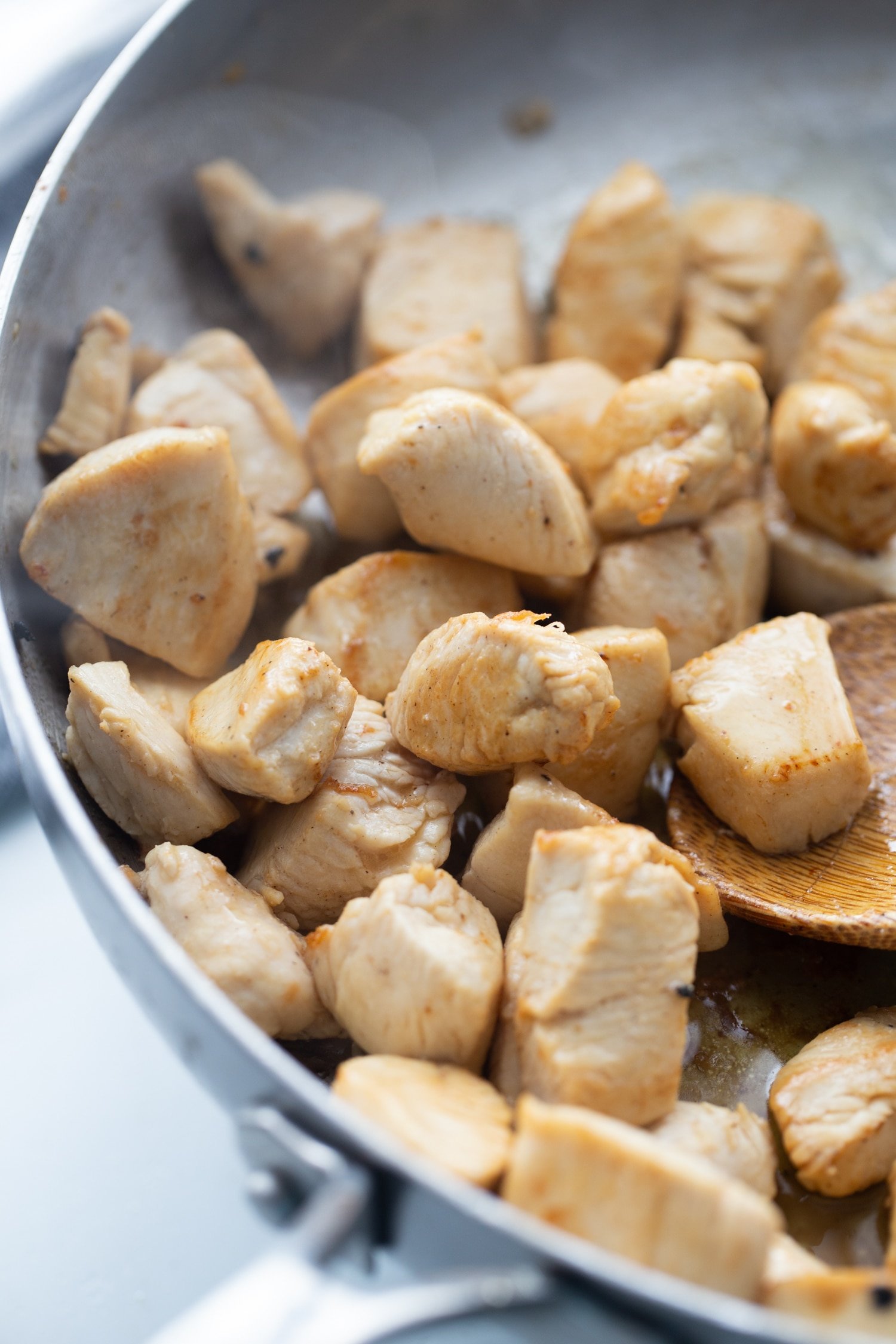 chicken cubes in a skillet browning