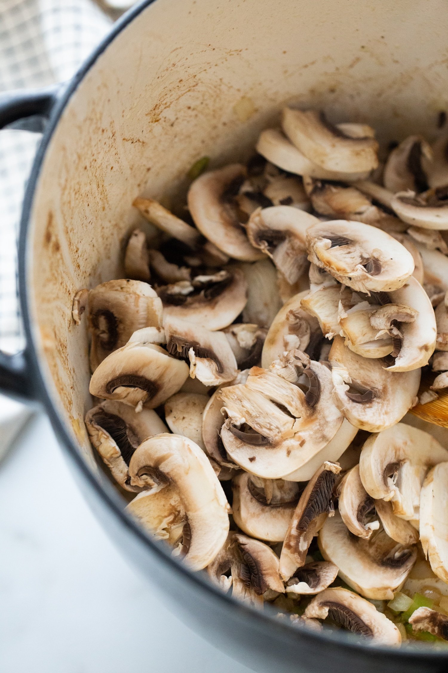 mushrooms sauteeing in a pot for beef stew