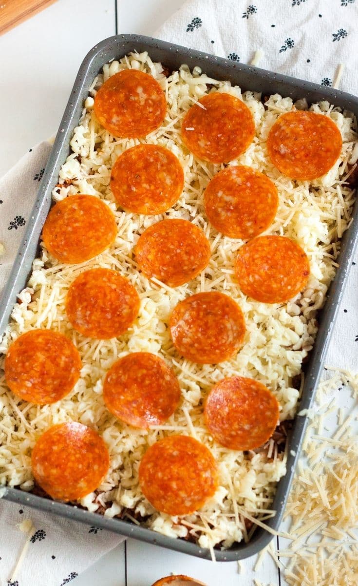 Placing cheese and pepperoni on the casserole