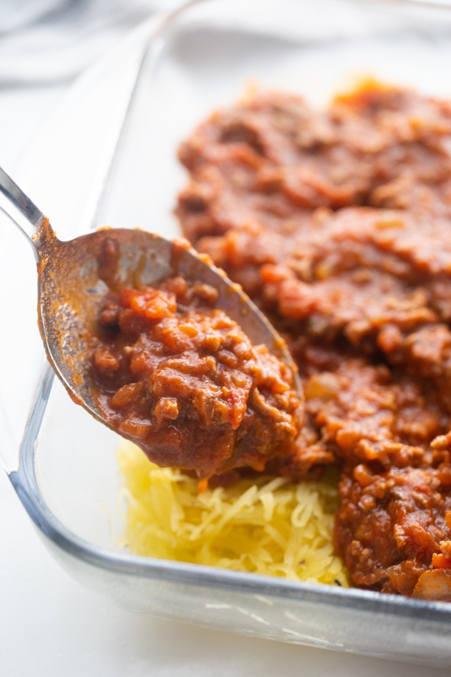 low carb spaghetti sauce on top of spaghetti squash in a glass baking dish 