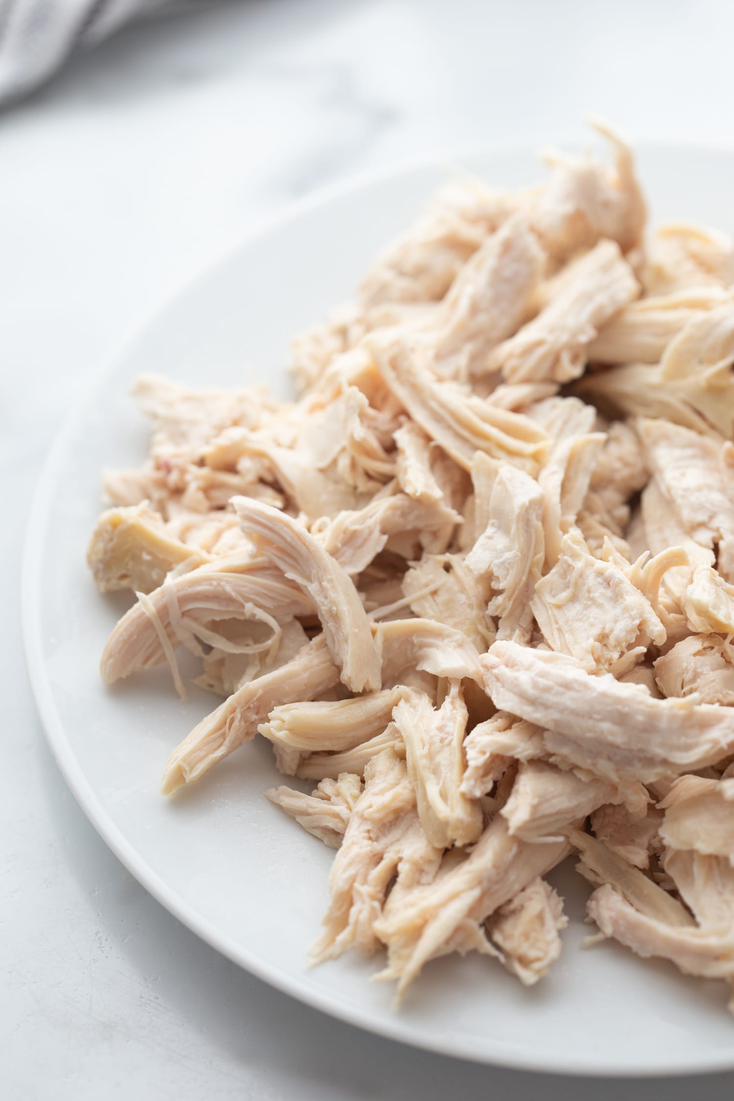 shredded chicken breasts on a white plate