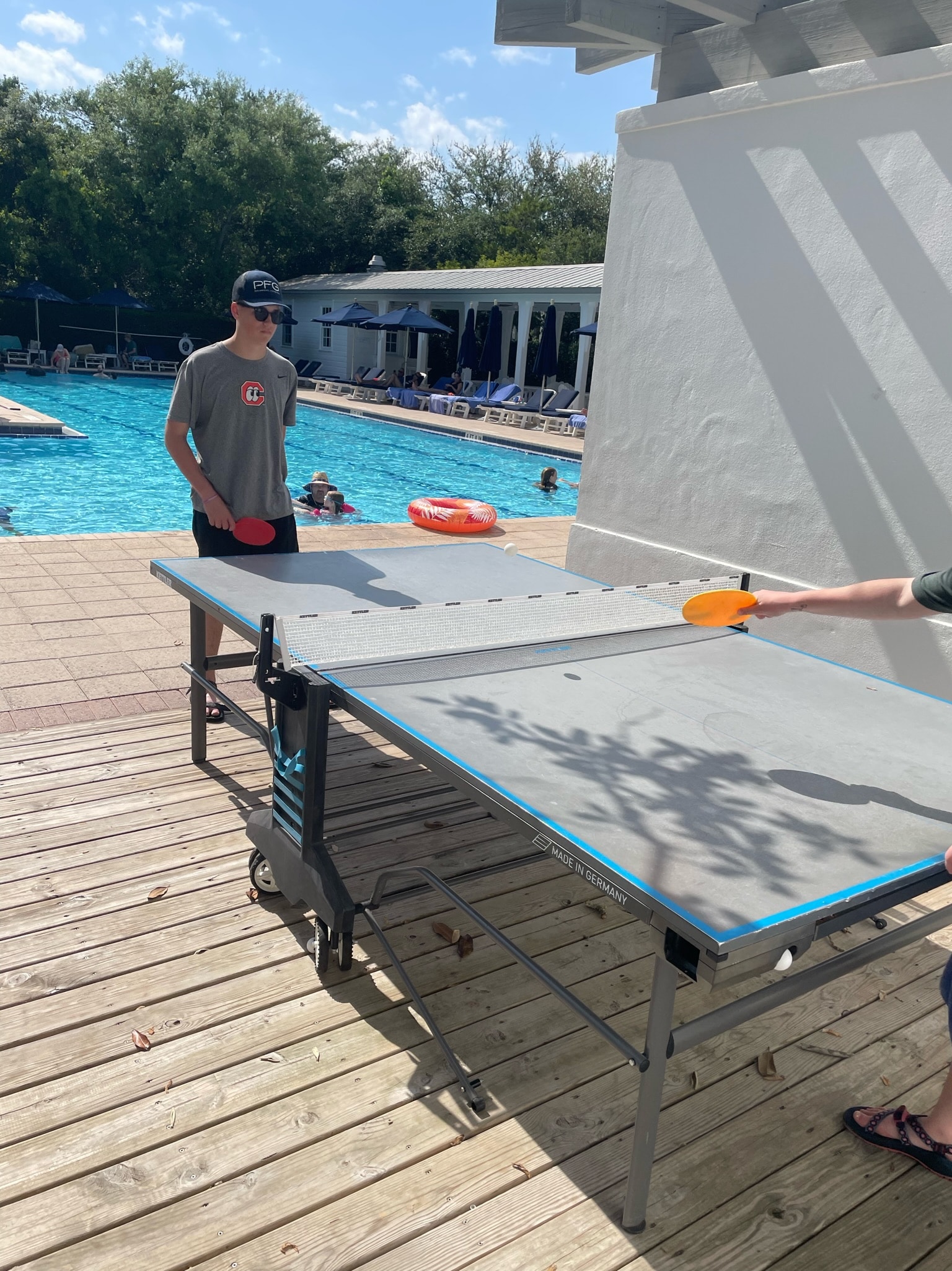 teenagers playing ping pong at the pool