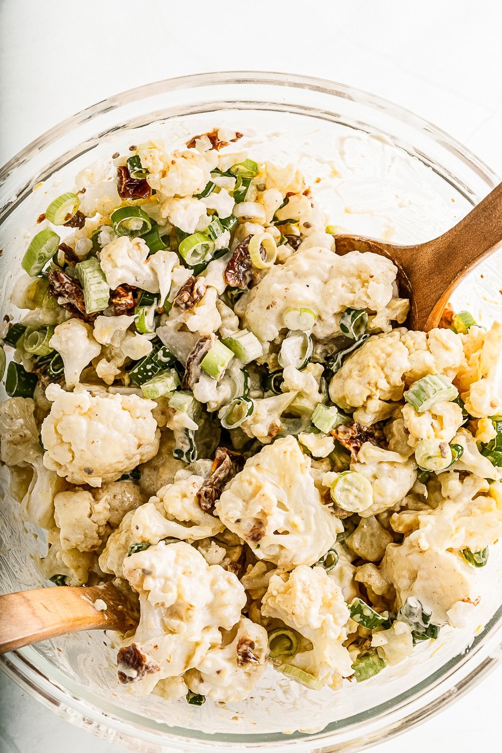 clear bowl cauliflower potato salad and wood spoon