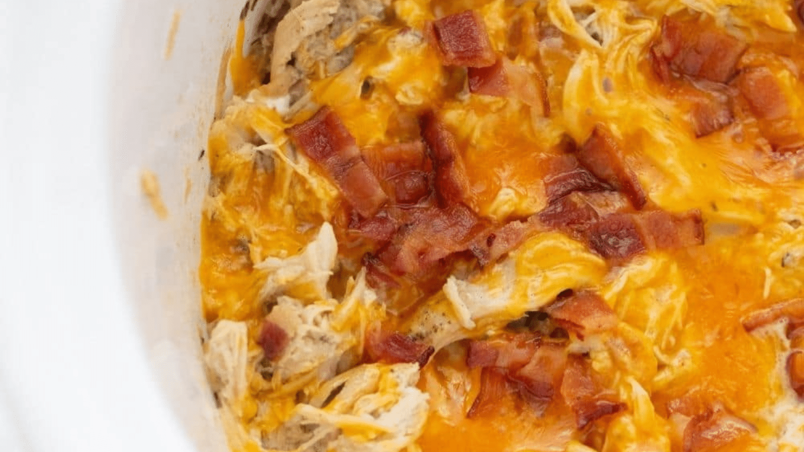 Close up of creamy chicken with chicken and bacon in slow cooker