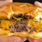 Close up of Wagyu Burger being held by 2 hands