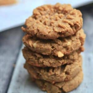5 sugar free gluten free peanut butter cookies stacked on top of each other on a gray background