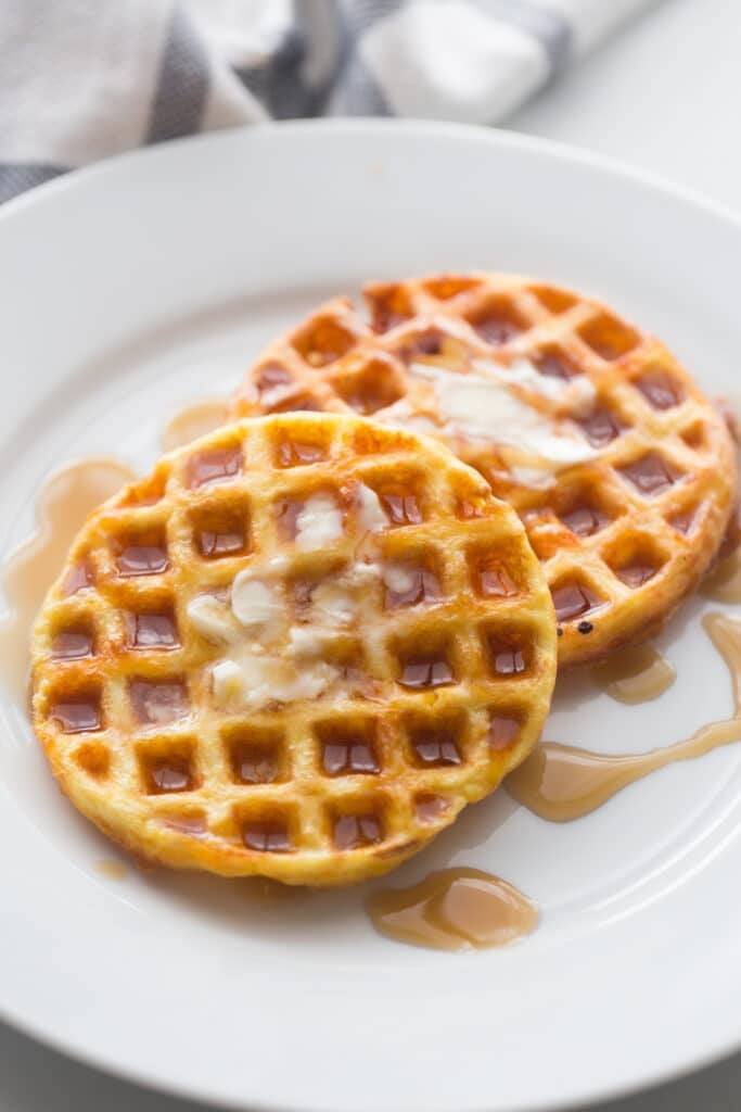 image of cooked breakfast chaffles plated and drizzled with butter and white syrup