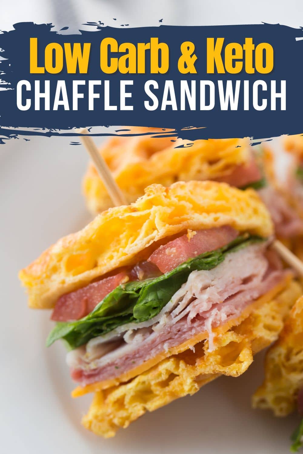Chaffle club sandwich cut diagonally with lettuce, tomato, chicken, bacon, and cheese filling