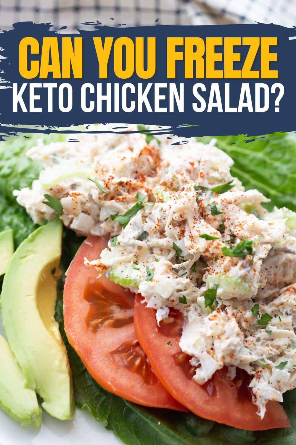 Bowl of keto chicken salad with lettuce, tomato, avocado, and shredded chicken topped with bacon