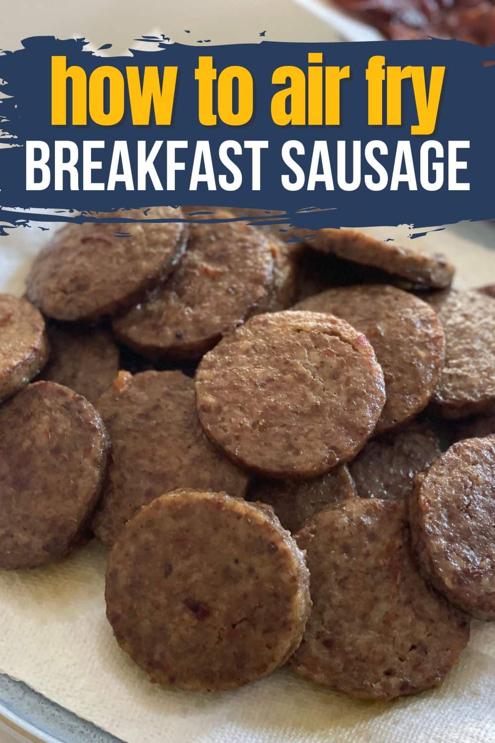 Overhead view of a pile of cooked sausage patties with the text "How to Air Fry Breakfast Sausage" overlaid in yellow and white.
