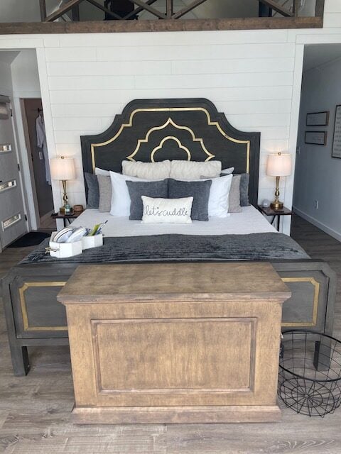 king size bed with gray headboard and tv cabinet at foot of bed,