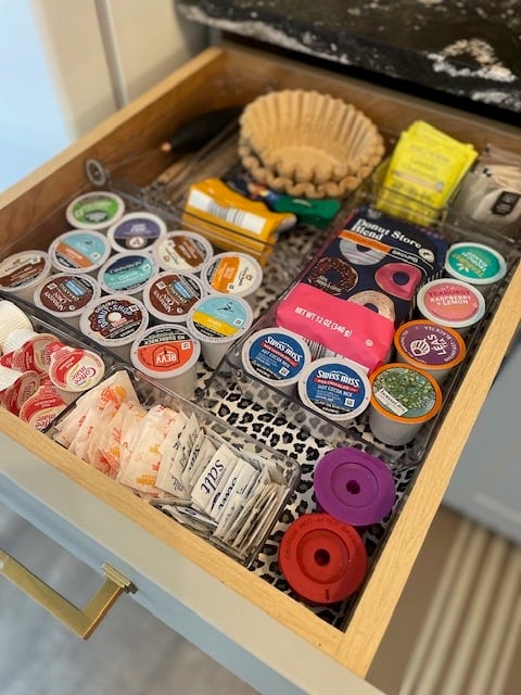 Coffee drawer open. Lots of k-cups, coffee filters, and sweeteners.