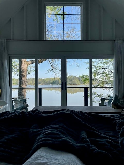 view from king sized bed looking out windows at river in the early morning