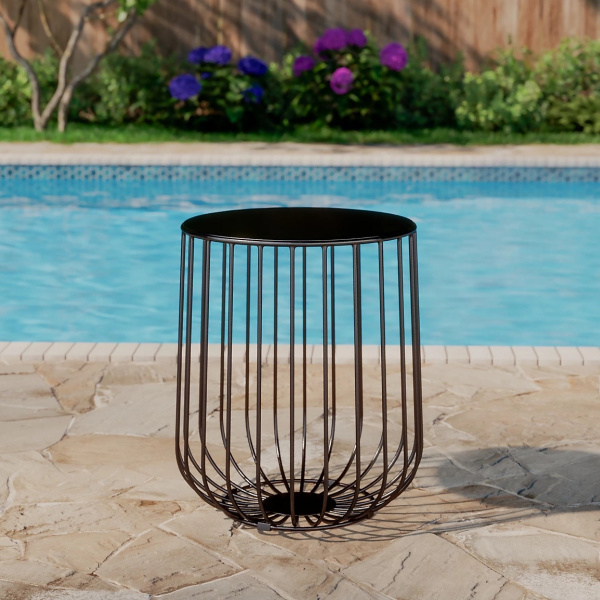 Mosaic Basket Accent Table stock image with pool in the background 